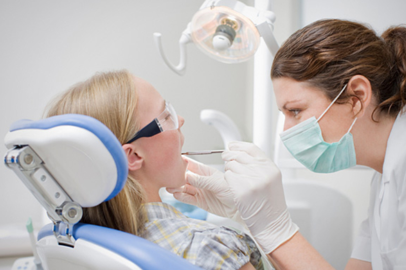 Leading Dentist FromA Dental Clinic Examining Her Patient’s Teeth