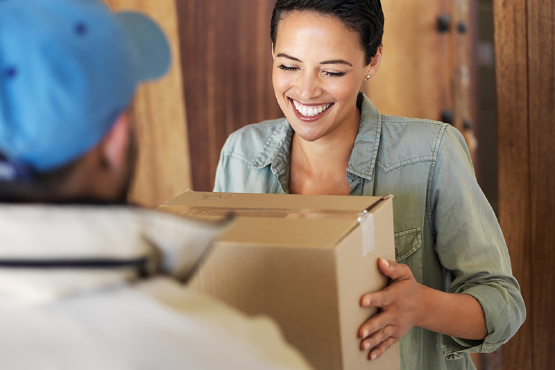 A woman receives a parcel from a delivery agent